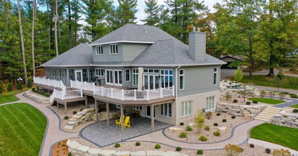 house with large deck and decorative landscape
