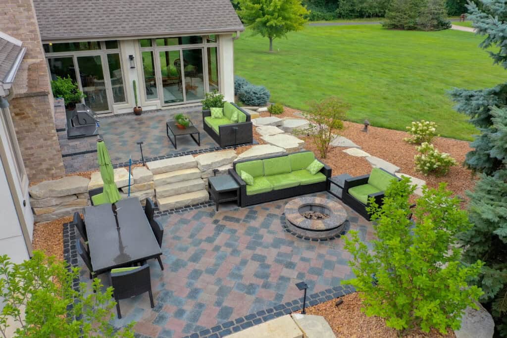 Garden room with stone seat wall and fire feature, part of the larger landscape design — Oshkosh, WI