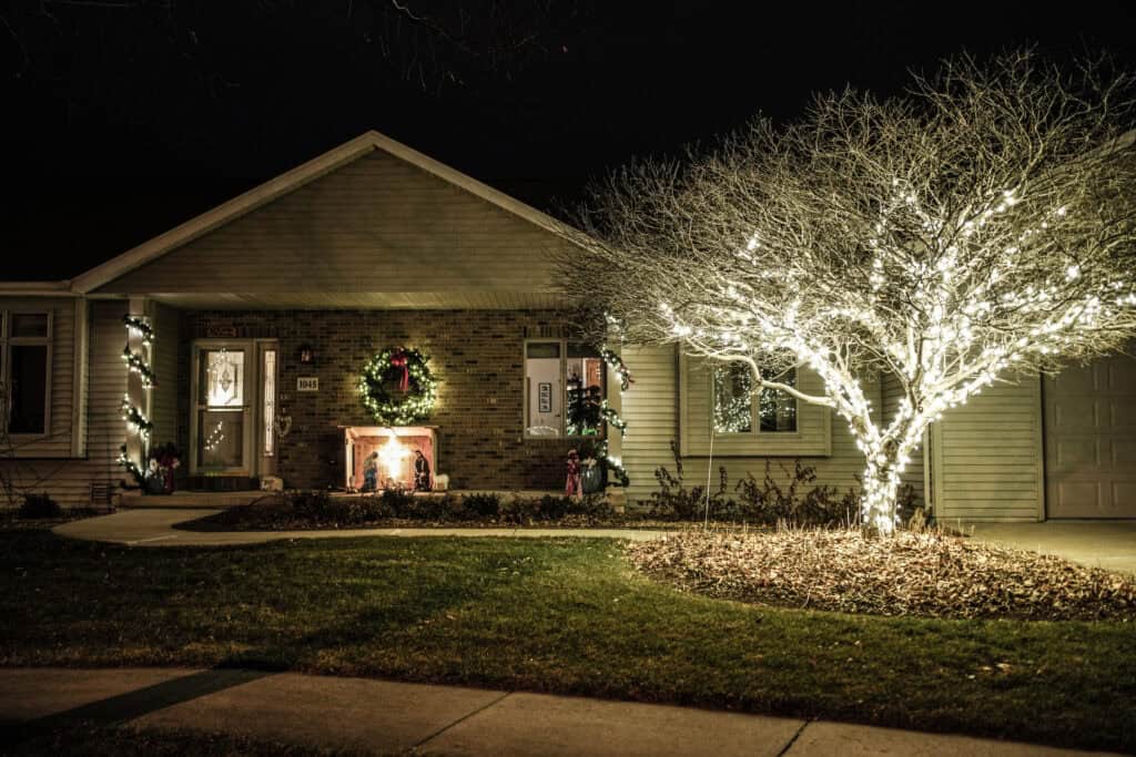 outdoor lighting tree wrapped canopy beside ranch home in Green Lake, WI