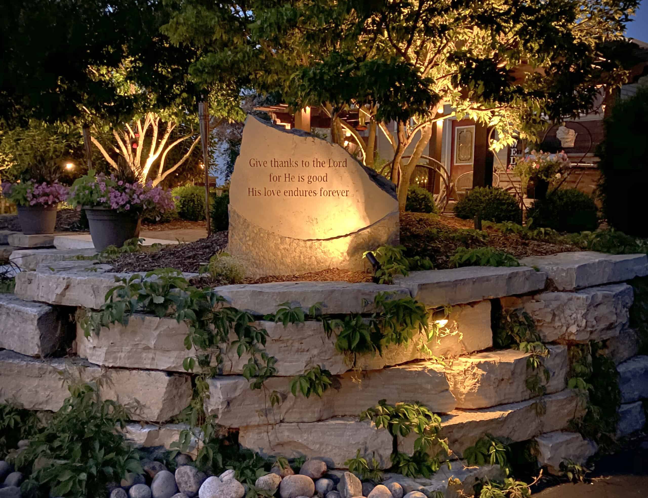 Curved garden retaining wall with perennials along a lawn in Green Lake, WI