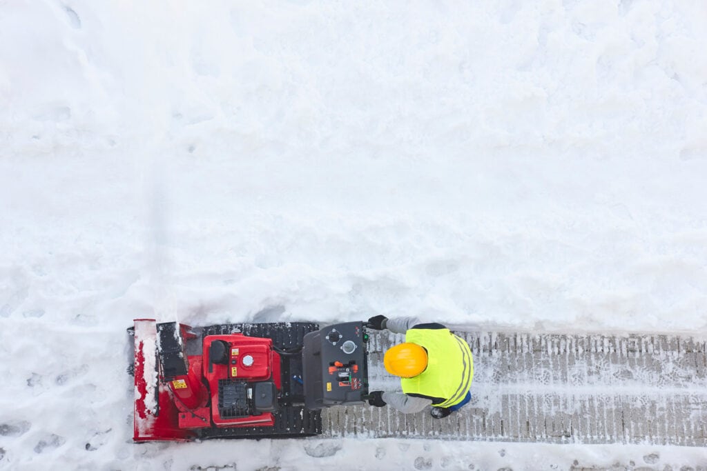 Snow plow removing snow near commercial building in Green Lake County, WI